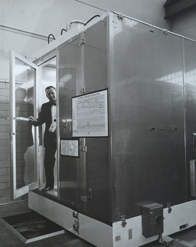 Cleanroom inventor Willis Whitfield, who passed away this month at age 92, steps out of a mobile cleanroom at Sandia National Laboratories, which could be transported to remote sites. (Photo courtesy of Sandia National Laboratories)
