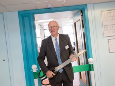 Lord Prior of Brampton cuts the ribbon during the official Saturn Process Development Laboratories opening